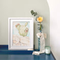 Load image into Gallery viewer, Querin Creations Framed artwork of a cactus on a blue desk with decorative items. Coastal Home decor