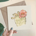 Load image into Gallery viewer, Querin Creations square Greeting card with a cactus watercolour illustration held by a hand with a beige craft envelope