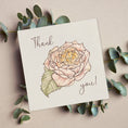 Load image into Gallery viewer, Querin Creations square greeting card with a pink rose illustration and 'Thank you!' text, surrounded by eucalyptus leaves on a beige background.