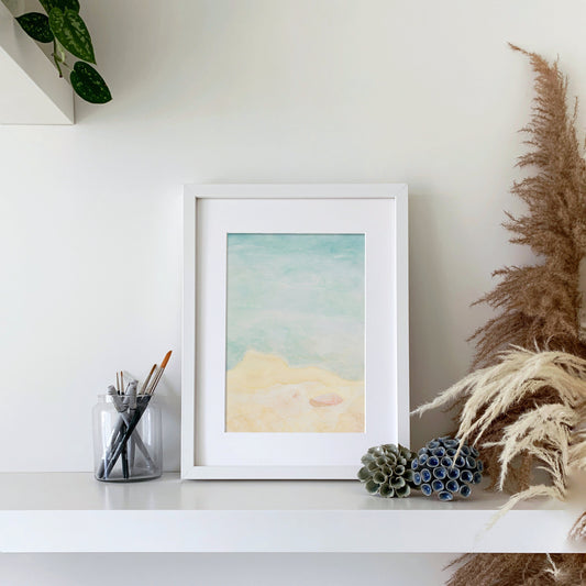 Querin Creations Watercolour seaside artwork on a shelf with decorative items and plants.