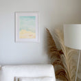 Load image into Gallery viewer, Querin Creations Framed modern watercolour or a seachell on a beach on a wall above a white sofa with boho decorative elements.
