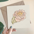 Load image into Gallery viewer, Querin Creations square greeting card with a pink rose illustration held by a hand with green nail polish.
