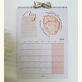 Load image into Gallery viewer, Calendar with a heart illustration and text on a light background
