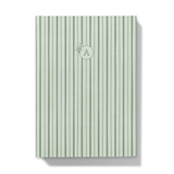 Green striped notebook with a floral monogram on a white background